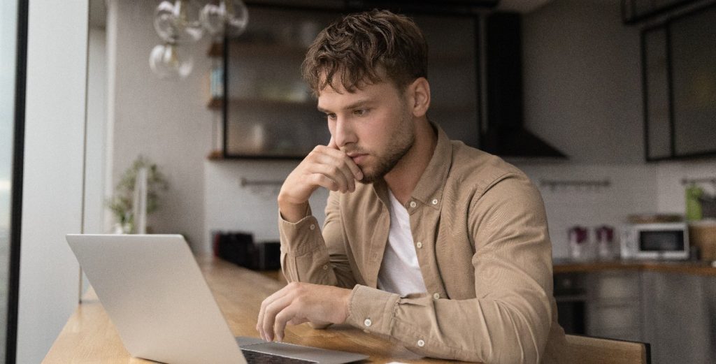 Man trying to search the dark web on laptop