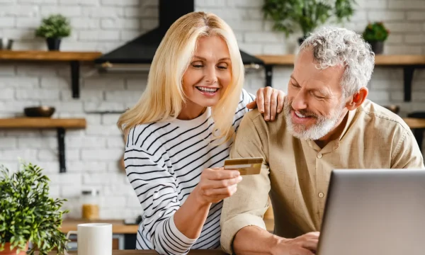 elderly couple shopping online with laptop