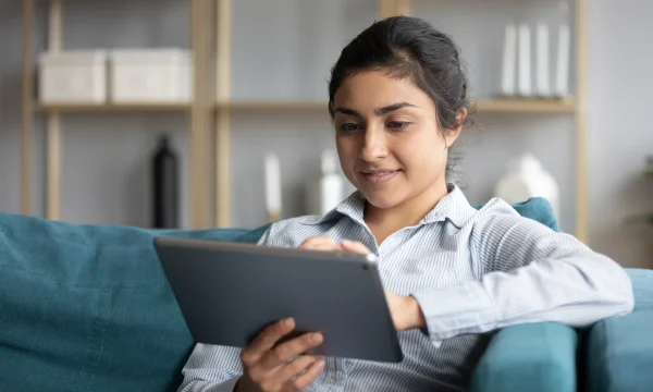 woman on couch working on her tablet